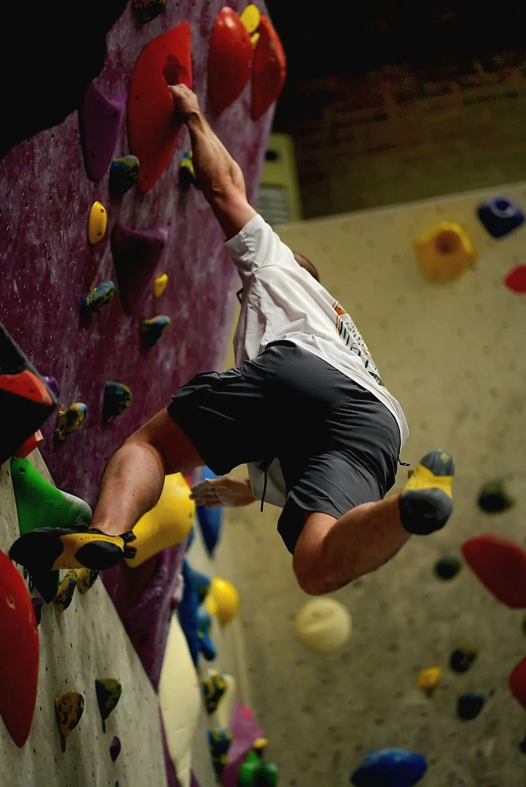 A beginner climber on a red coloured boulder route during the Learn to Climb Course at Dublin Climbing Centre