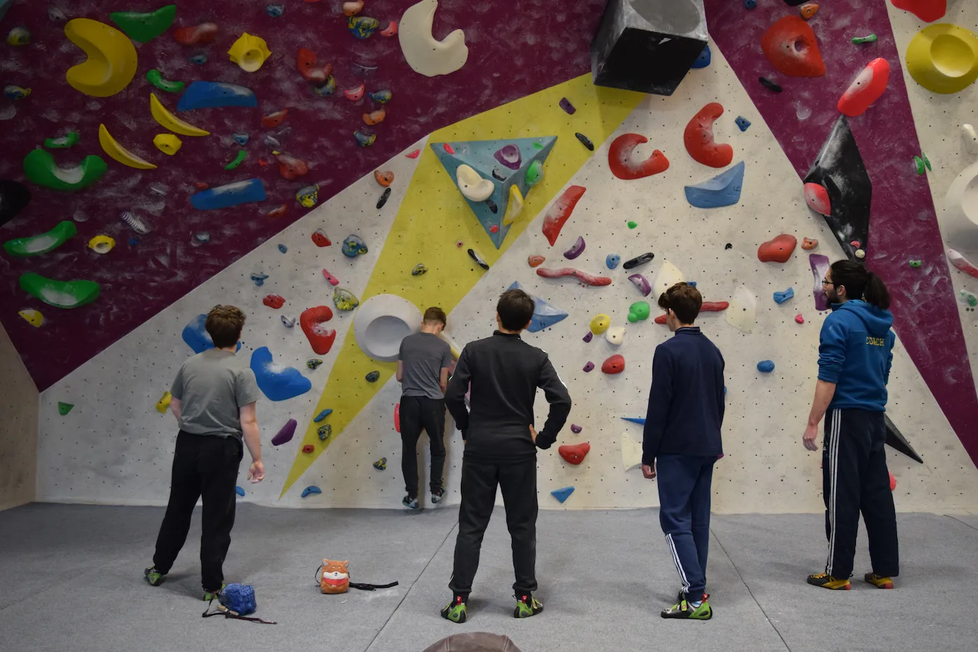 An instructor guides 4 males on the bouldering wall at Dublin Climbing Centre