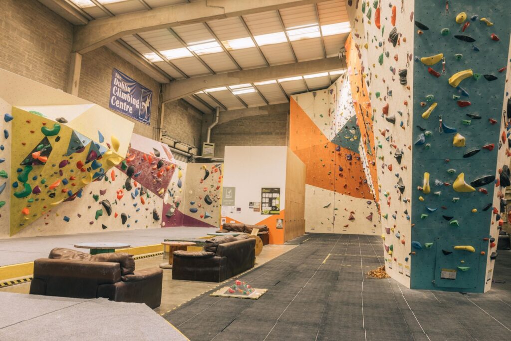 A wide angle photo featuring tall walls, bouldering walls, and seats and tables in Dublin Climbing Centre