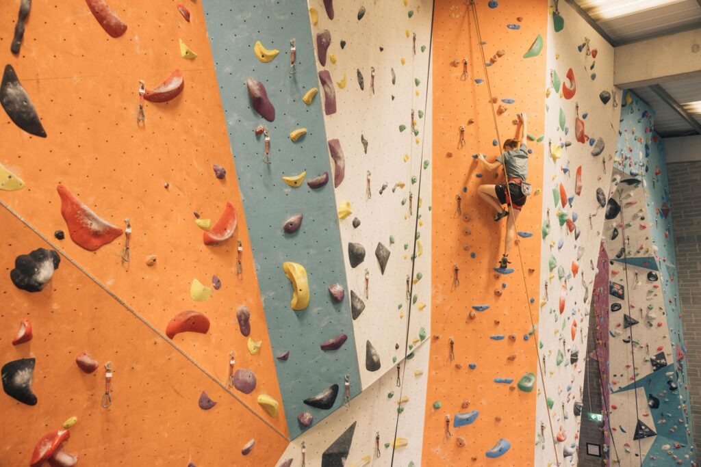 Climber lead climbing on a multi-coloured wall at Dublin Climbing Centre, Tallaght
