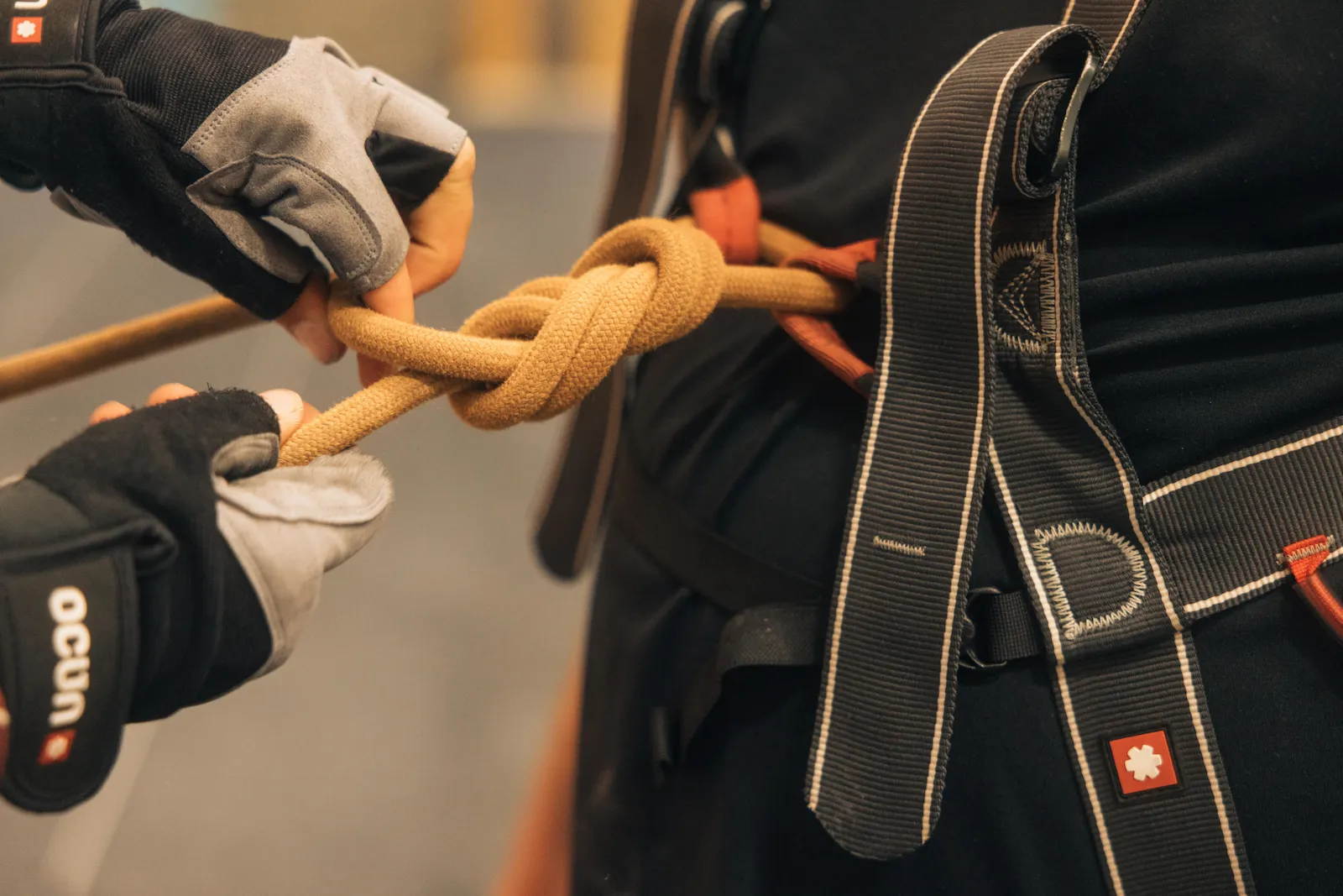 A close up shot of a climber tying a figure of eight knot onto their harness during the Learn to Climb Course at Dublin Climbing Centre