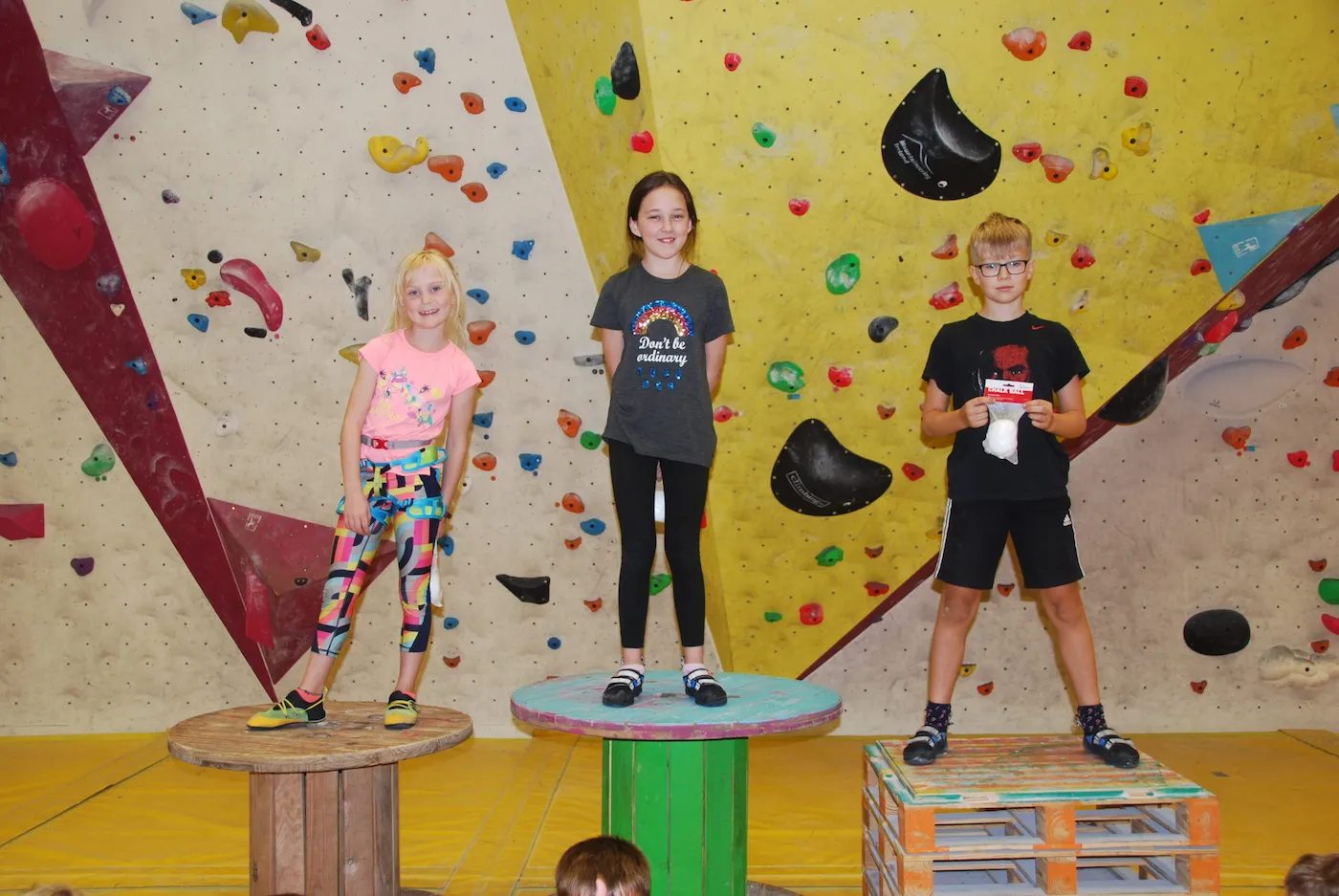 Young climbers celebrating on the podium at the bouldering wall in a competition during a birthday party at Dublin Climbing Centre