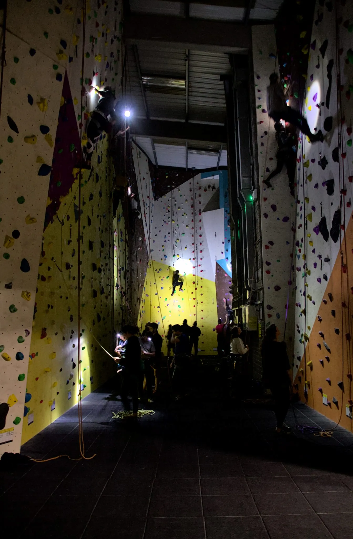 Several climbers in the canyon section of Dublin Climbing Centre with head torches with the lights off during a head torch night