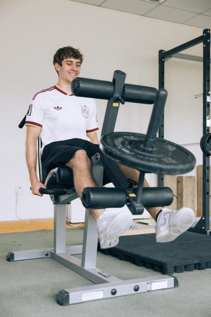 Man using a leg extension machine in the weights room at Dublin Climbing Centre