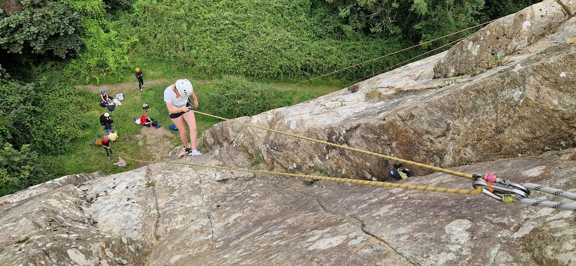 A young climber abseiling on real rock at an outdoor climbing camp in Dalkey quarry