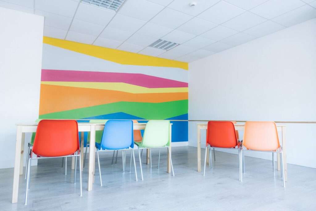 Party room with colourful mural and stacking chairs at Dublin Climbing Centre