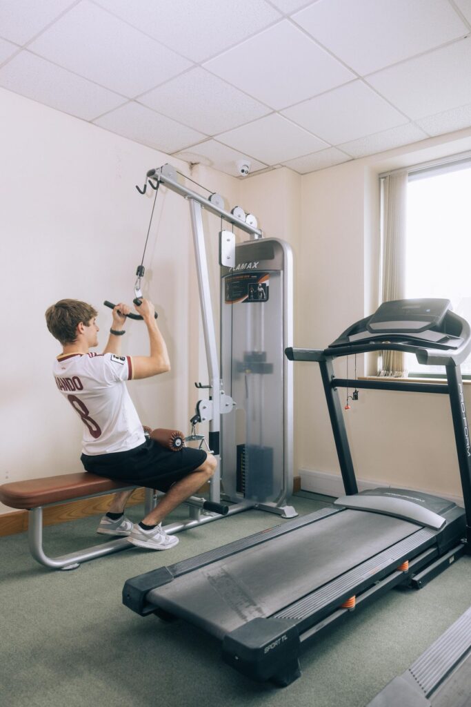 Man using a lat pulldown machine beside a treadmill at Dublin Climbing Centre